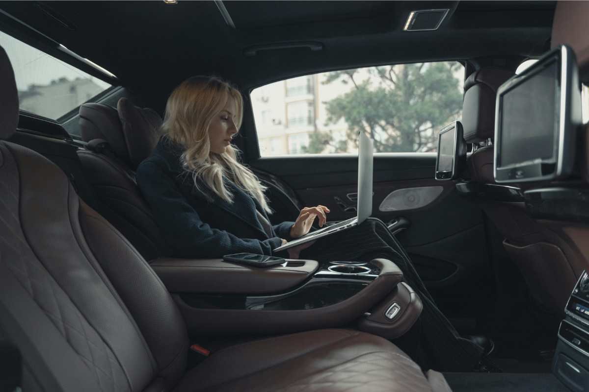 A business Women working on laptop sitting in a limo-Corporate Transportation